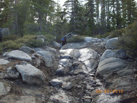 1982 Toyota 4Runner - A 1982 Toyota 4Runner navigates a challenging, rocky off-road path surrounded by dense forest.
