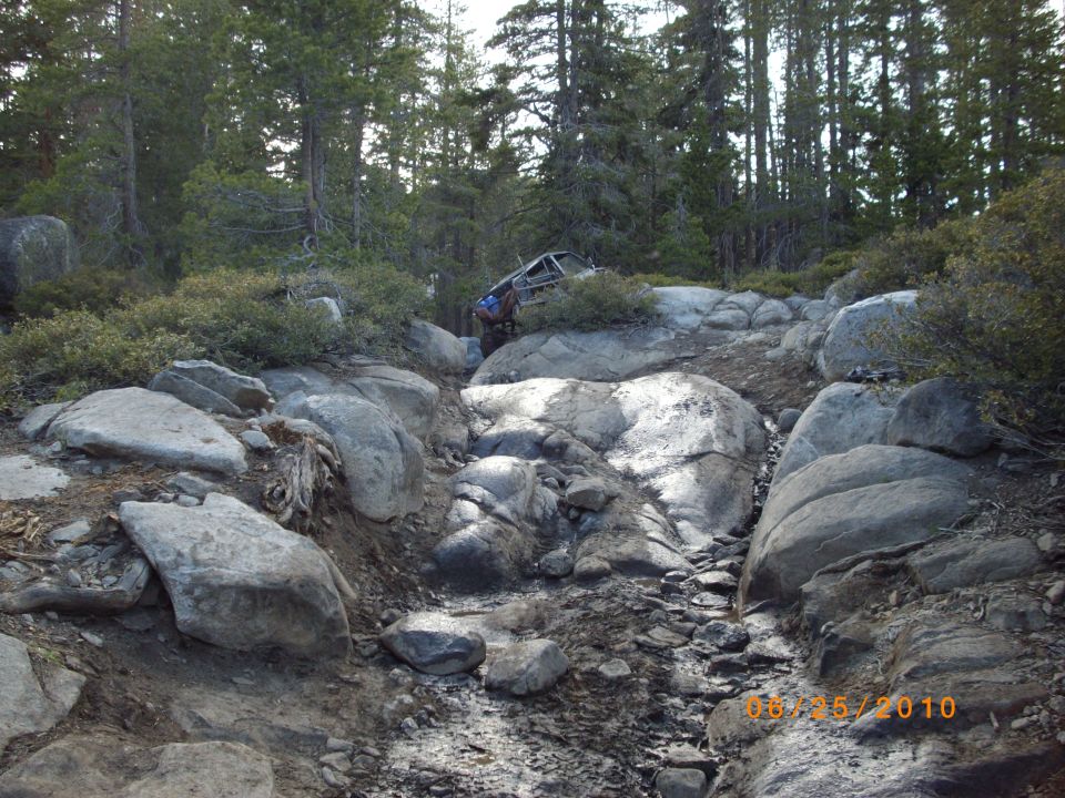 1982 Toyota 4Runner on a steep, rocky trail with trees and bushes