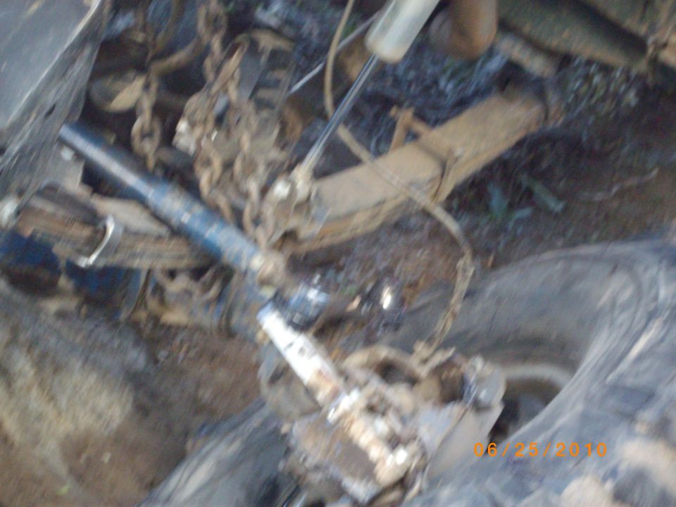 Close-up of a vehicle's suspension system with chains attached
