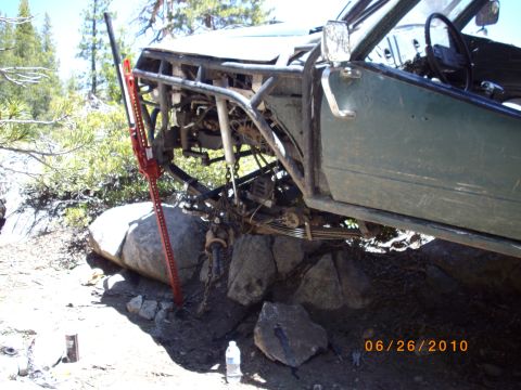 1982 Toyota Pickup/SR5 - Off-road vehicle with a hi-lift jack positioned on rocks, showing modified suspension.