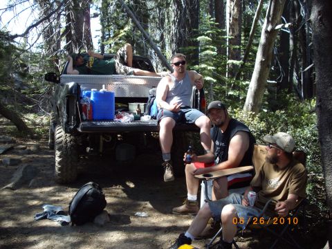 1982 Toyota Pickup/SR5 - People relax in the bed of a pickup truck during a camping trip in a wooded area.