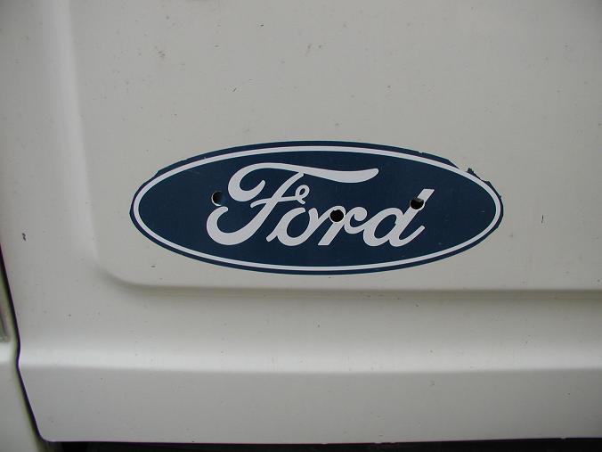 At some point in the past, the original Ford emblem was lost and replaced with this sticker. It's gotten ratty over the years, and has the original mounting holes punched through. That's a recipe for rust, so I had to fix that...
