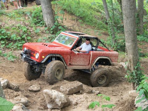 1978 Ford Bronco - This red 1978 Ford Bronco tackles a challenging off-road course with a driver behind the wheel.