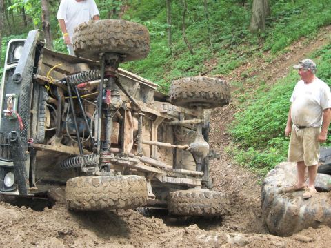 1978 Ford Bronco - An off-road vehicle has rolled onto its side during an off-road excursion, with onlookers observing the situation.
