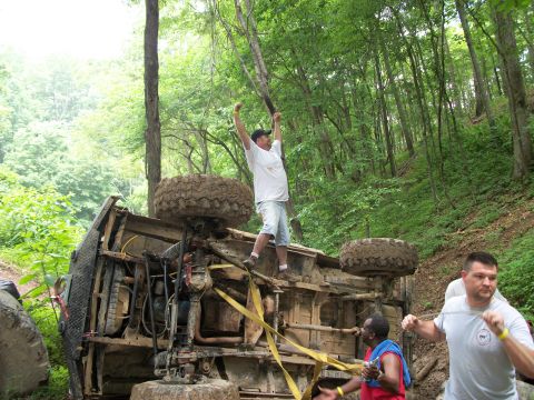 1978 Ford Bronco - Off-road vehicle recovery in progress after flipping onto its side in a wooded area.