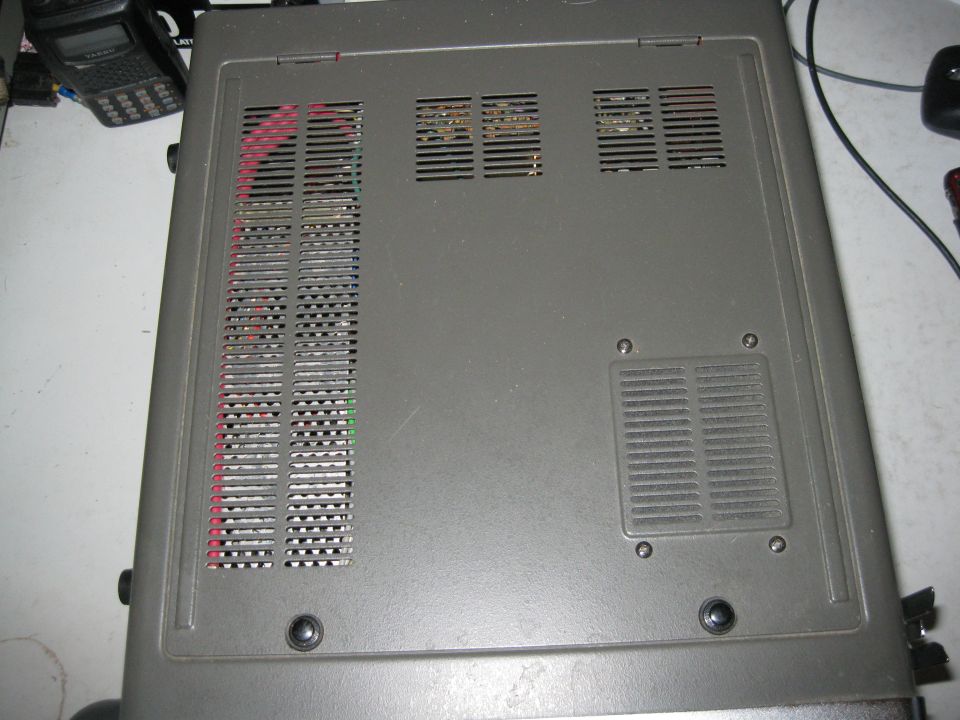 Top view of a gray electronic device with ventilation slots and visible wiring