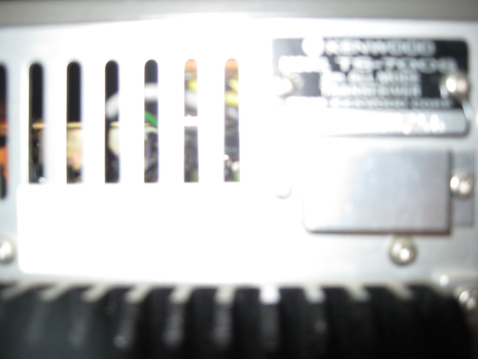 Close-up of a car stereo amplifier with vents and a metal plate