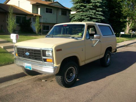 1986 Ford Bronco - This Ford Bronco is parked on a street in front of a house with a mailbox nearby.