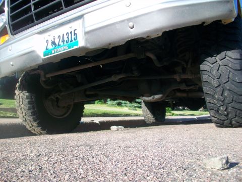 1986 Ford Bronco - The underside of a vintage Ford Bronco reveals its robust suspension and off-road tires.