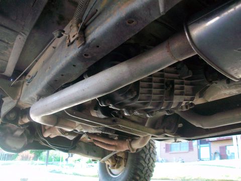 1986 Ford Bronco - Underside view of a vehicle's drivetrain components including the transmission and exhaust system.
