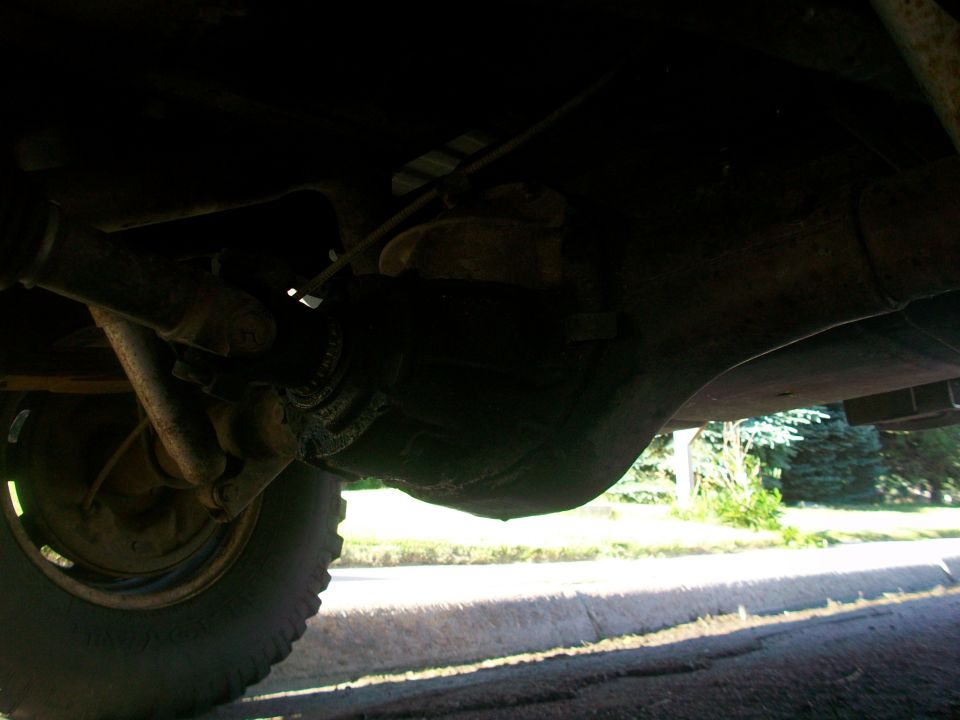 Underside view of a vehicle's drivetrain and tire