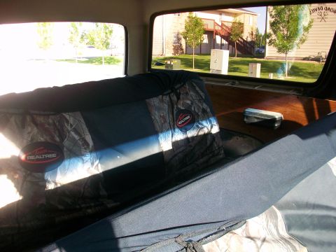 1986 Ford Bronco - Vehicle interior with camouflage seat covers and wooden trim visible.