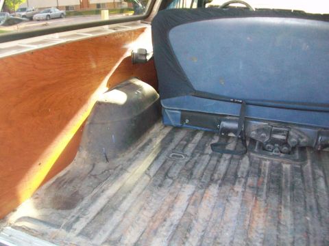 1986 Ford Bronco - Interior view of a vehicle's cargo area, showing wood paneling and a blue seat.