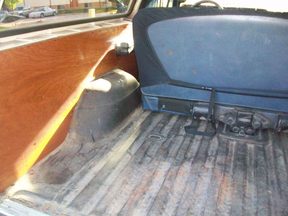 Interior cargo area with wood paneling and blue seat. SUPERMOTORS.NET watermark visible