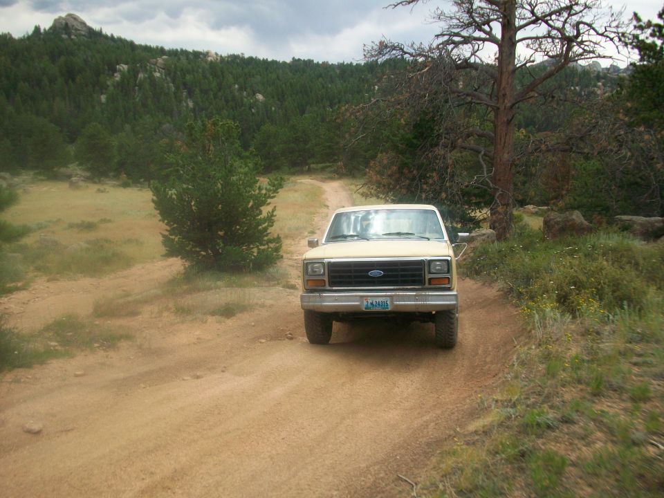 Tan 1986 Ford Bronco front view on dirt road
