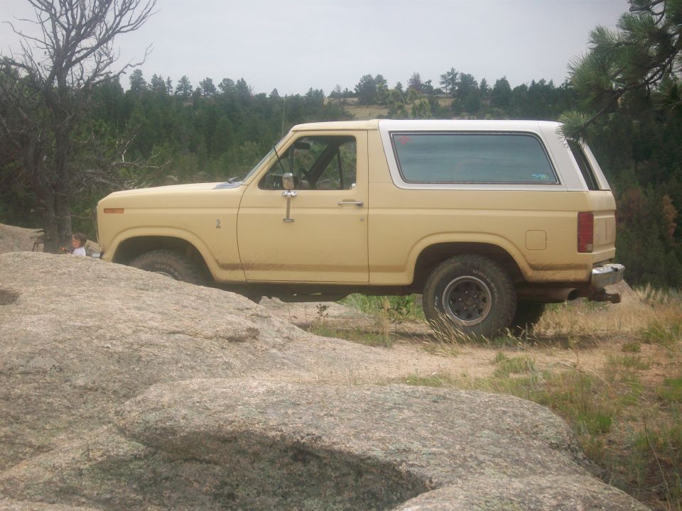 Yellow Ford Bronco parked on rocky terrain