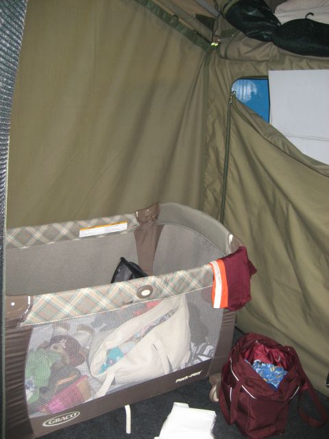 1996 Ford Bronco - The interior of a tent setup, a portable playpen and a backpack filled with belongings.
