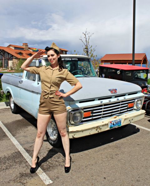 1963 Ford F-100 - Woman in a vintage military-style outfit poses with a 1963 Ford F-100 pickup truck.