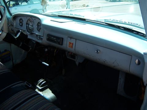 1963 Ford F-100 - The interior of a 1963 Ford F-100 pickup truck shows its dashboard, steering column, and floor shifter.