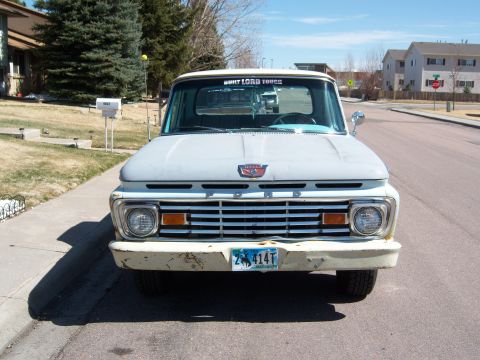 1963 Ford F-100 - This truck features a prominent horizontal grille and a red Ford emblem on the hood.
