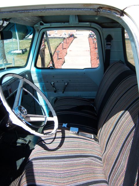 1963 Ford F-100 - Interior view of a light blue truck, showing the seats, steering wheel, and door panel.