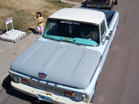 1963 Ford F-100 - This 1963 Ford F-100 pickup truck is seen from a high angle, with a young girl playing nearby.