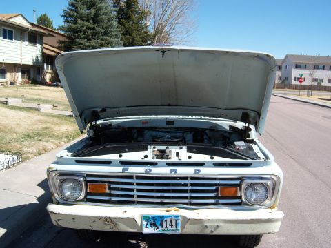 1963 Ford F-100 - Front view of a white Ford F-100 truck, hood raised, revealing the engine compartment.