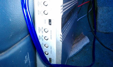 1992 Ford Bronco - Close-up of a car amplifier with various knobs and settings visible, next to blue wiring.