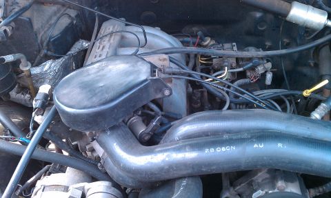 1992 Ford Bronco - Close-up view of an engine bay, showing various hoses, wiring, and engine components.