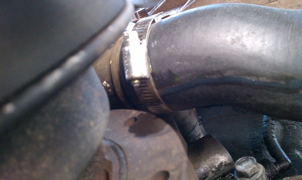 Close-up of a metal hose clamp on a black rubber hose
