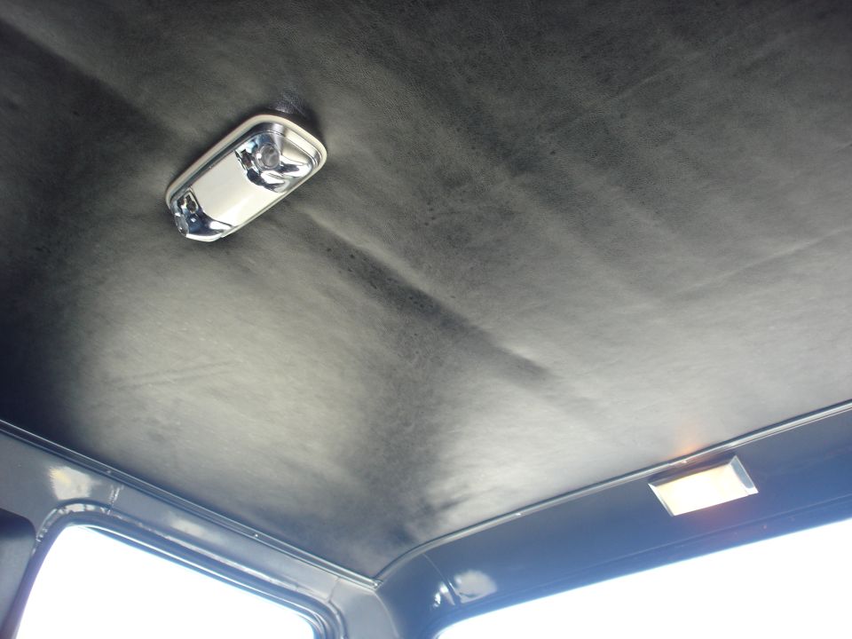 Interior view of a vehicle's headliner with two dome lights visible