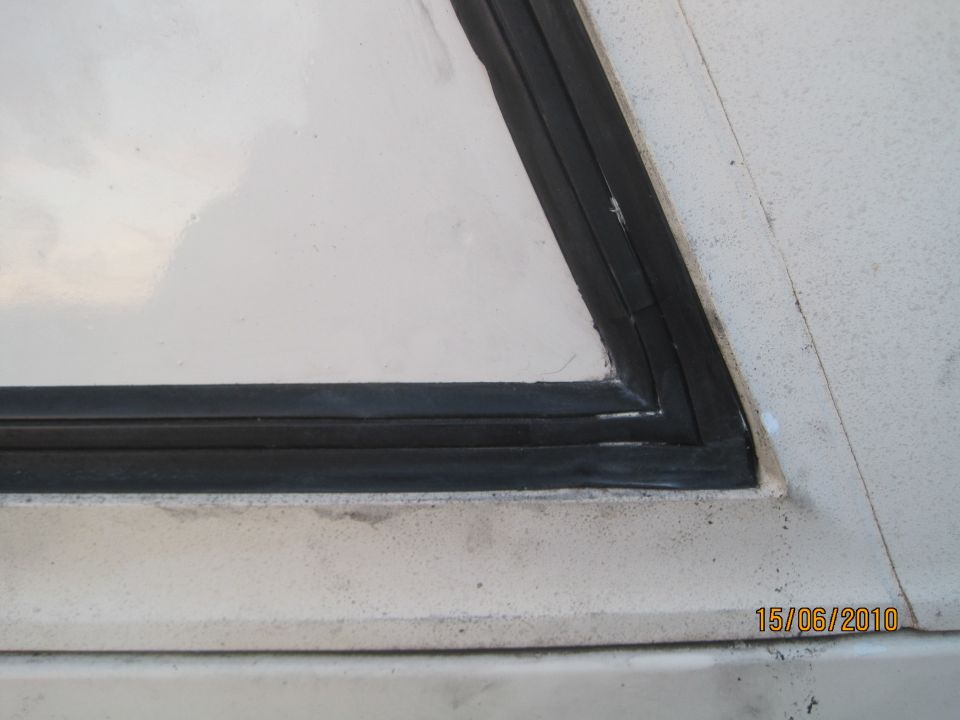 close-up of a triangular window seal on a white vehicle