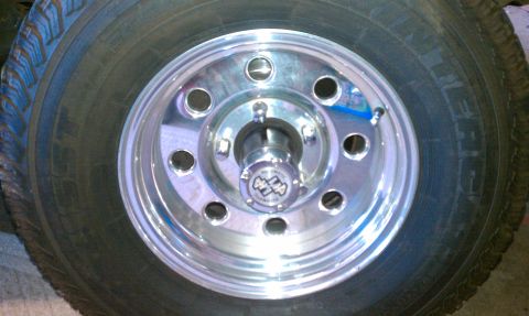 1992 Ford Bronco - A close-up view of a vehicle's wheel and tire, a chrome rim and a 4x4 emblem on the hub.