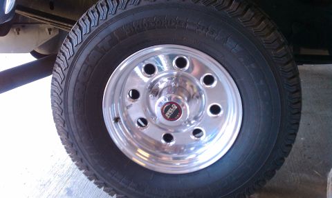 1992 Ford Bronco - Close-up of a chrome Weld wheel and tire, with a portion of the vehicle's frame visible.