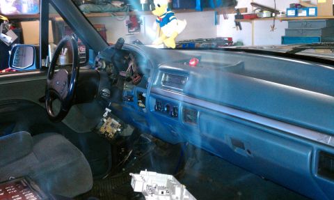 1992 Ford Bronco - The interior of a vehicle shows a disassembled dashboard with exposed wiring and controls.