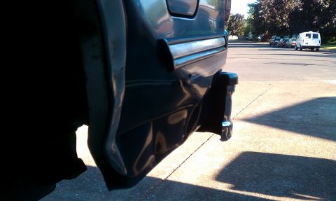 1992 Ford Bronco - The rear of a 1992 Ford Bronco is visible, with other vehicles parked on a street in the background.