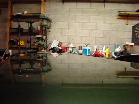 1948 Jeep Wrangler - A cluttered workbench in a garage displays various tools, including drill presses, and an assortment of supplies.