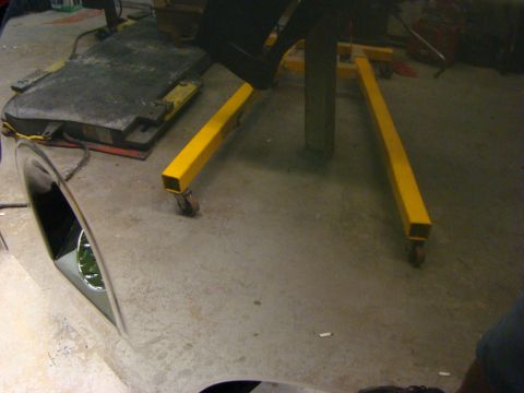 1948 Jeep Wrangler - A vehicle fender is visible next to an engine hoist in a workshop setting.