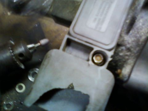 1990 Ford Bronco - Tight, out-of-focus shot of a gray TFI-IV ignition module with its printed instruction label still on the face, mounted on the side of a di…