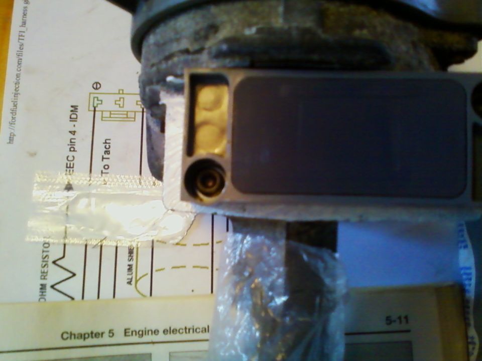 Gray Ford TFI ignition module with gold pins on a wiring diagram page