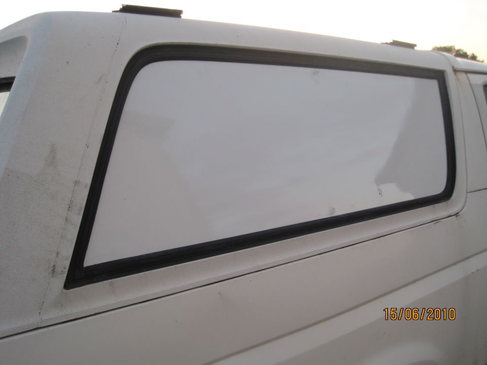 White SUV's rear side window and panel. Date stamp 15/06/2010 visible