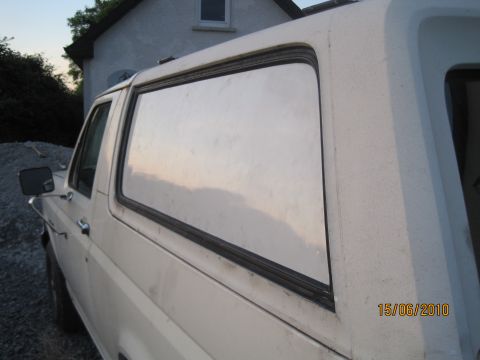 1989 Ford Bronco - A white SUV is parked outdoors with a house in the background.