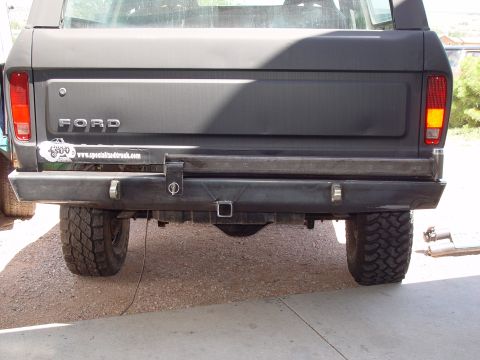 1993 Ford Bronco - Rear view of a black Ford Bronco a custom bumper and a "specializedtruck.com" sticker.