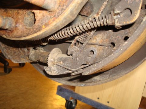 1995 Ford Bronco - Close-up of a corroded vehicle brake system, showing internal components.
