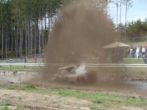 1978 Ford F-150 - A 1978 Ford F-150 is stuck in a mud pit, creating a large spray of mud and water.