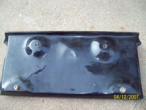 1995 Ford Probe - A black license plate bracket is shown from the front, with visible screw holes and minor damage.