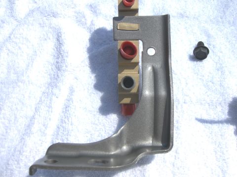 1970 Chevrolet Camaro - A metal bracket with red and gold fittings and a separate bolt are laid out on a white towel.