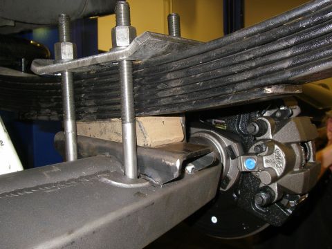 1990 Ford Bronco - Close-up of a vehicle's rear suspension leaf spring and brake assembly.