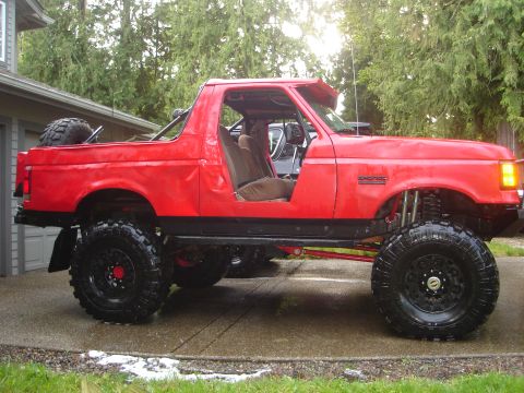 1989 Ford Bronco - This lifted red Bronco has its doors removed, its interior and off-road capabilities.