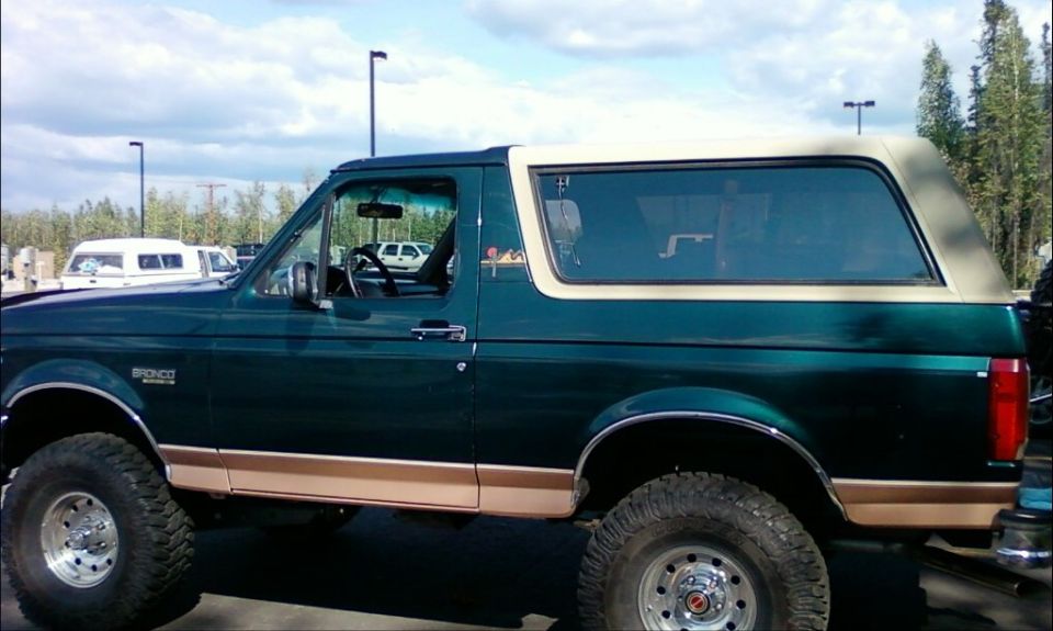 1994 Ford Bronco side view, green with tan trim and removable top